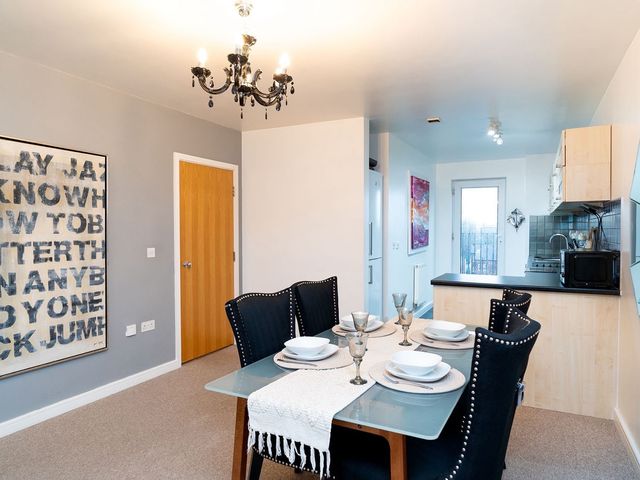 A dining room with a table and chairs at Apartment, Sleeps 6 with Stadium View, Manchester