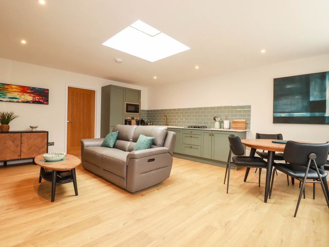 A living room with a sofa and dining area at Rule retreat in Penzance