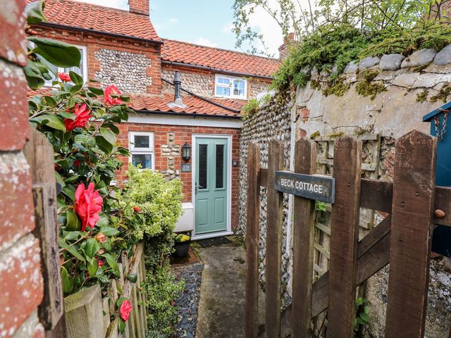 A door and gate in an outdoor space at Beck Cottage in Sheringham