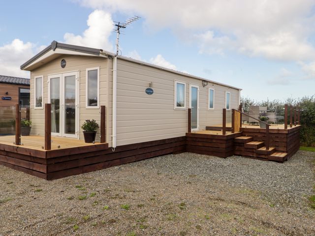 A mobile home with a deck and stairs at Seascape near Little Haven