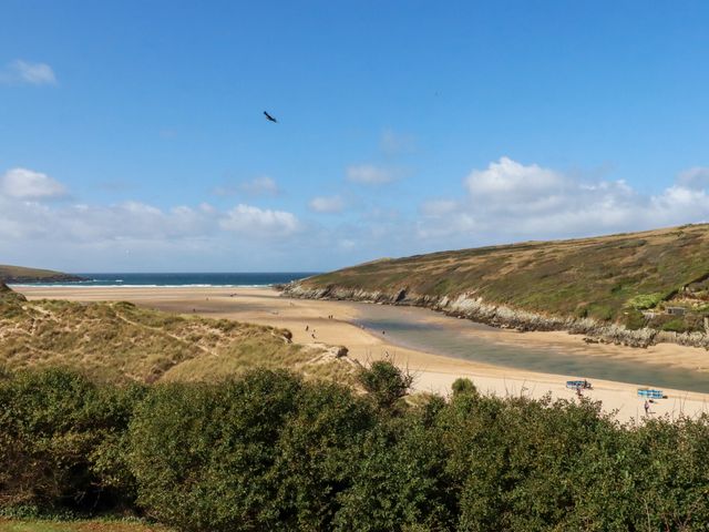 A beach with a river and hills at Chy-an-Lowena in Crantock