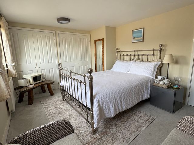 A bedroom with a bed and a bedside table at Hafan y Tyddyn in Newport, Pembrokeshire