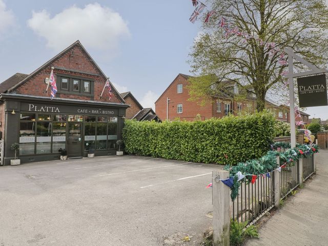 A building exterior with a sign and flags at Platta Cafe Bar Bistro in Ilkeston