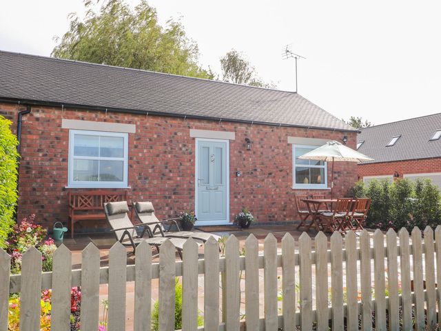 A brick exterior with a garden seating area at The Croft in Ashbourne