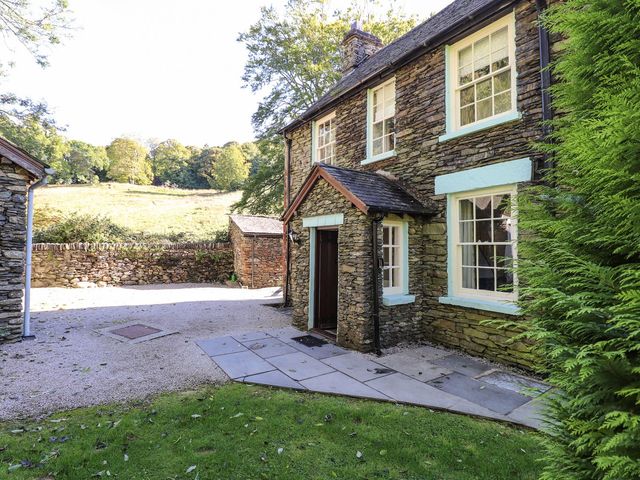 An outdoor area with a stone wall and pathway at Jessicas Cottage in Windermere
