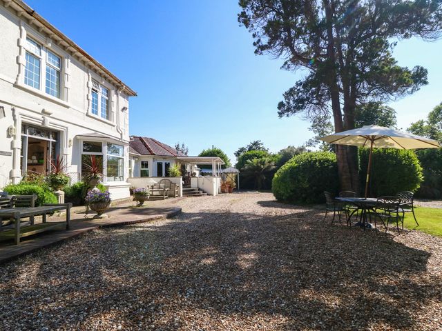 A garden with seating and a table under an umbrella at Meifod Country House Caernarfon