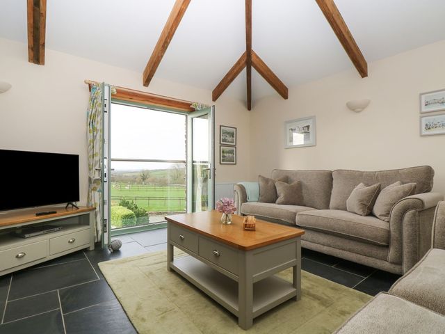 A living room with a sofa and television at Ash Cottage in Truro