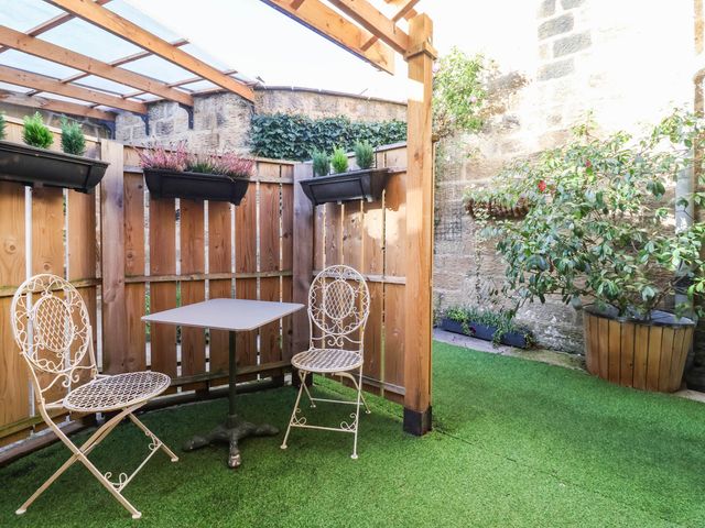 A garden with a table and two chairs at Winksey Cottage in Harrogate