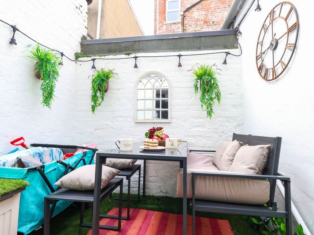 An outdoor patio with furniture and plants at Flat 1, 2 Wooperton Street Weymouth
