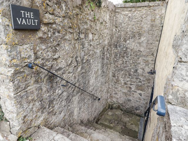 An outdoor stairway with stone walls and a sign at The Vault Hotel Room in Gileston near St Athan
