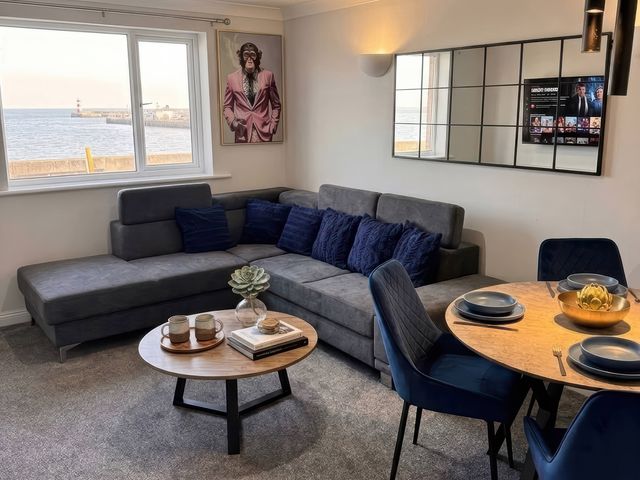 A living room with a sofa and dining area at Flat 3 Brown Lodge in Sheerness
