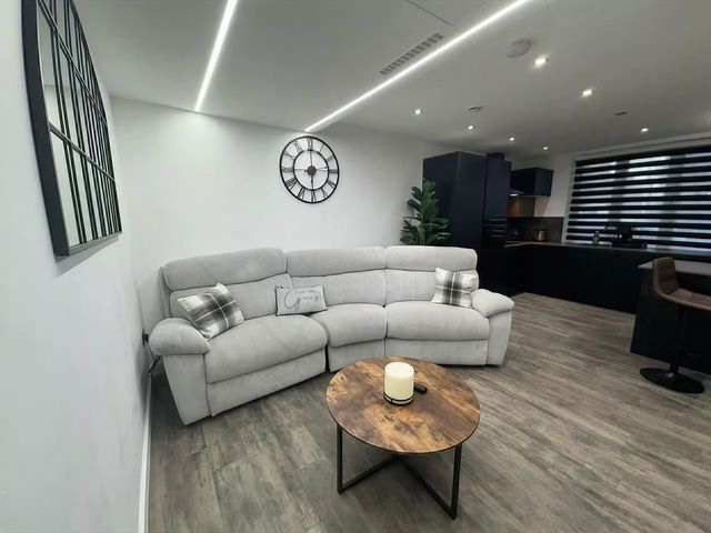 A living room with a sofa and coffee table at Flat 1 Hilltop Court in Uxbridge