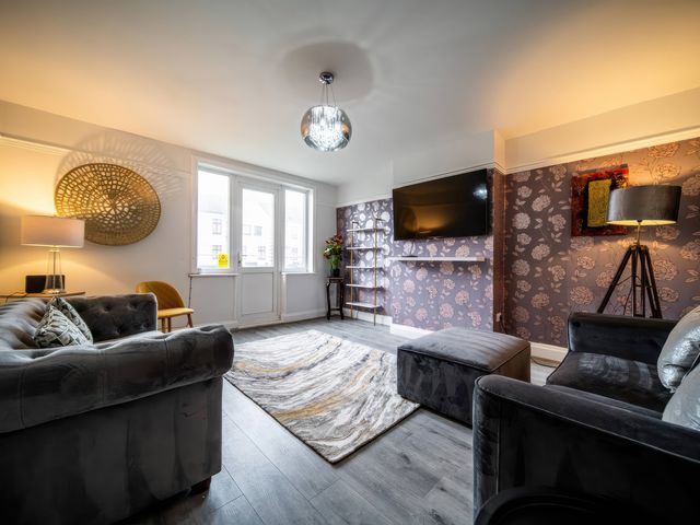 A living room with a sofa and television at Flat with Terrace Style Rooftop in Thornton-Cleveleys