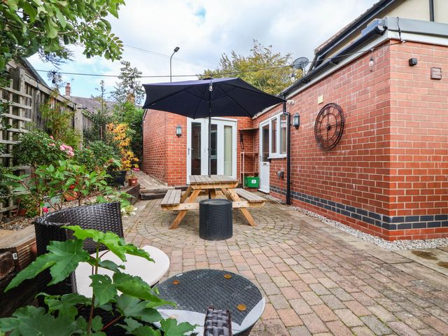 A garden with a table and umbrella at The Snug in 