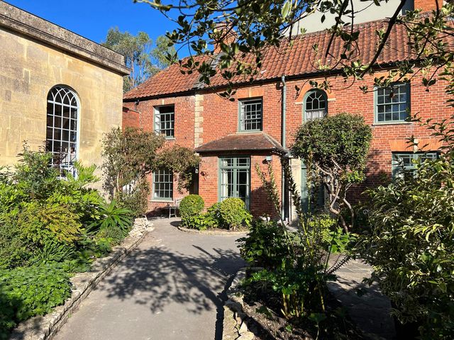 A garden with a brick house and plants at Kylemore in Glastonbury