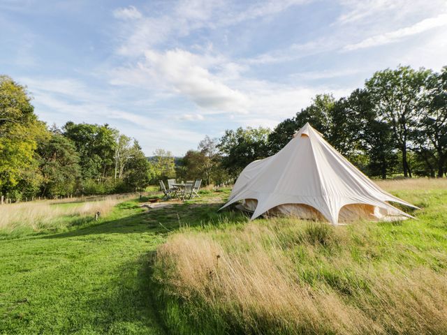 A bell tent with a table and chairs in the garden at Bell Tent Builth Wells