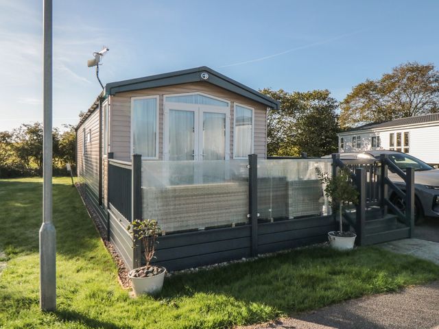 A mobile home with a deck and plants at 19 Finch in 
