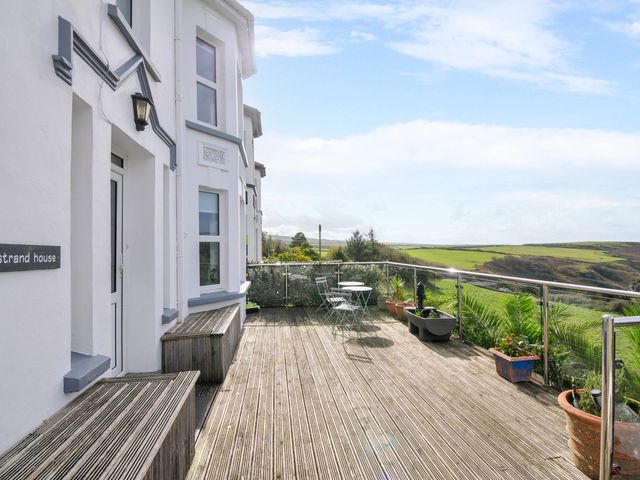 An outdoor patio with furniture and plants at Strand House Treknow near Tintagel