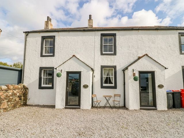 A house with a table and chairs in the outdoor area at Holly in Cleator