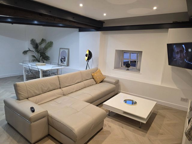 A living room with a sofa and dining table at Liverpool Penthouse, sleeps 8 Liverpool