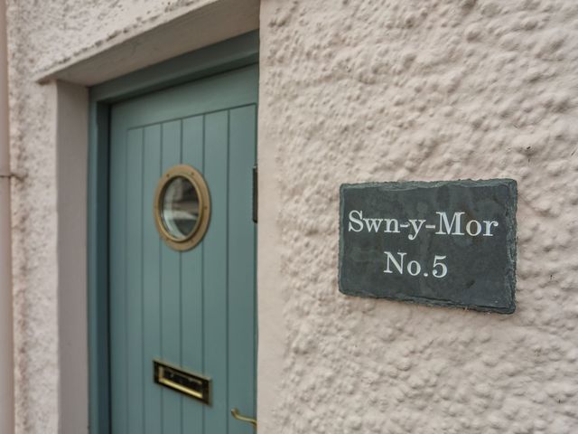 A door with a circular window and sign reading Swn-y-Mor No. 5 at Swn y Mor (Wexham) Beaumaris