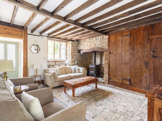 A living room with a sofa, coffee table, and fireplace at a property
