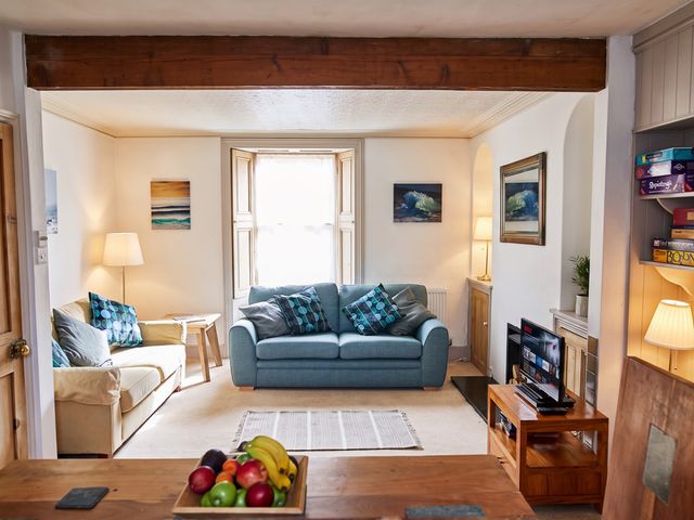 A living room with a sofa, lamp, and television at The Old Barn in Manchester