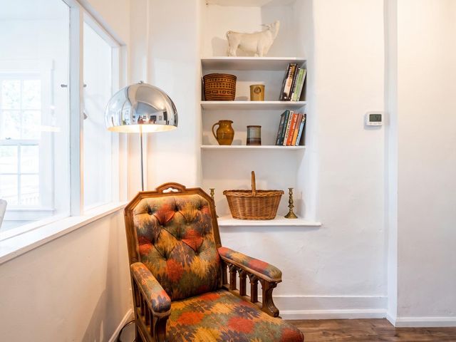 A living room with a chair and books on a shelf at a property in unspecified location