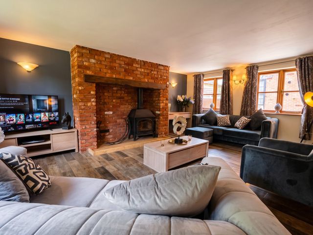 A living room with a fireplace and television at The Old Barn in Manchester