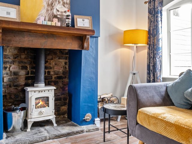 A living room with a stove and lamp at The Old Barn in Manchester