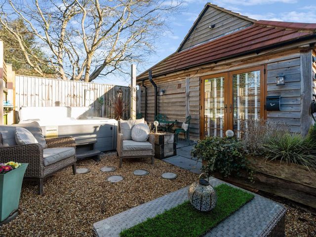A garden with a hot tub and seating area at the property location