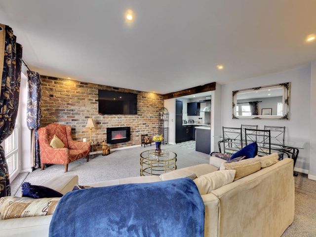A living room with a sofa, chair, coffee table, and television at the property location