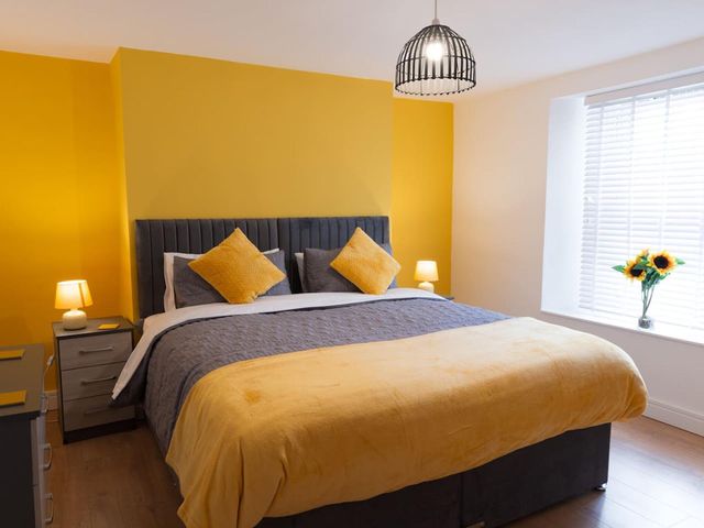 A bedroom with a bed, lamp, and flowers at 