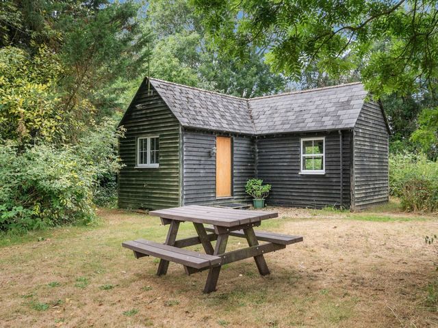 A cabin with a table and benches at The Hideaway in 