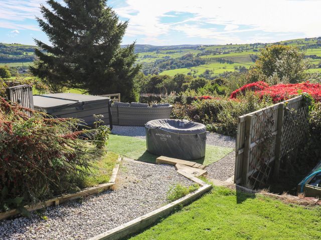A garden with a hot tub and seating at Lacey Hey House Halifax