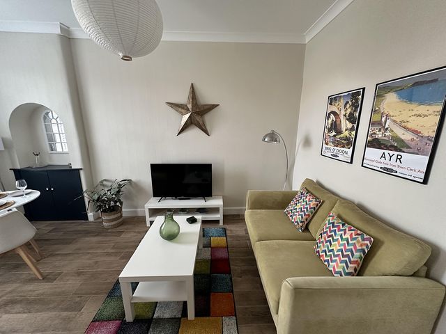 A living room with a sofa, coffee table, and television at the property in 