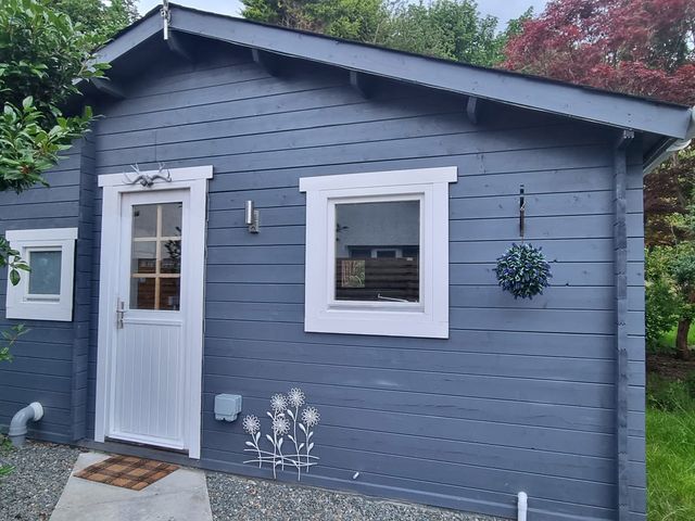 An exterior view of a lodge with a door and windows at 2 bed Lodge near Dunoon on the Shore Front, Innellan near Dunoon