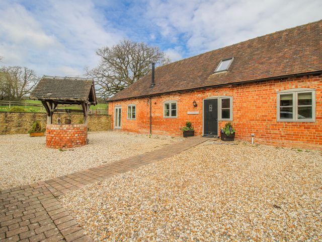 A brick house with a well and gravel area at The Milking Parlour in Westhope
