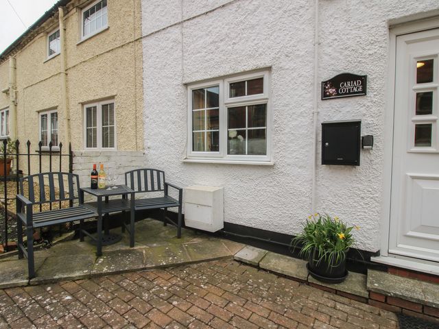 An outdoor sitting area with a bench and table at Cariad Cottage in Ludlow