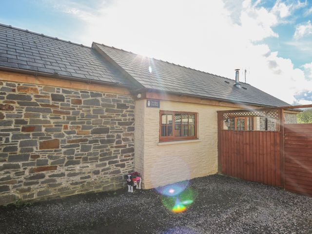 The exterior of a stone and stucco house with a wooden window and gate at Yr Hen Llaethdy Blaen-Cil-Llech near Newcastle Emlyn