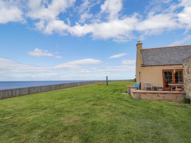 An outdoor area with a house and ocean view at Braehead Croft Portessie near Buckie