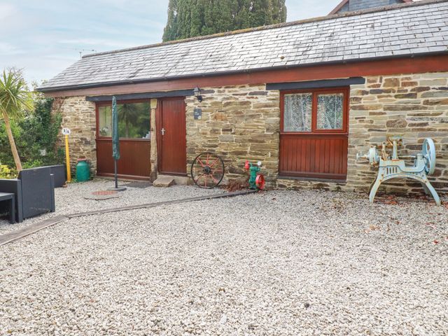 An outdoor area with a stone wall and door at Barn Cottage in Dobwalls