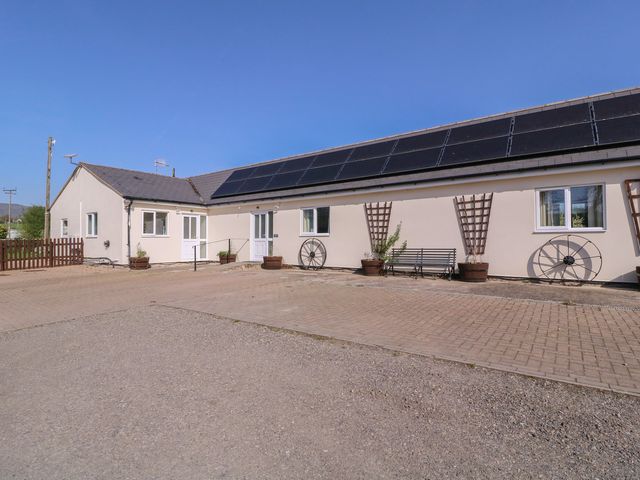 An outdoor view of a building with solar panels at The Turbles - Swallows Nest in Castlemorton near Welland
