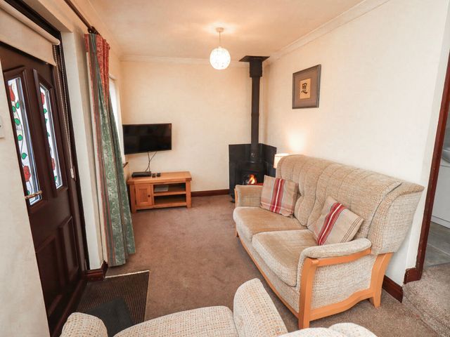 A living room with a television and sofa at Ghyll Bank Bungalow Staveley near Windermere