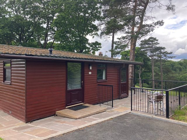 A cabin with decking and chairs at Violet Lodge in Saltburn-by-the-Sea