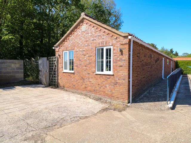 An outdoor view of a brick building with a gate at Mill Lodge Brisley