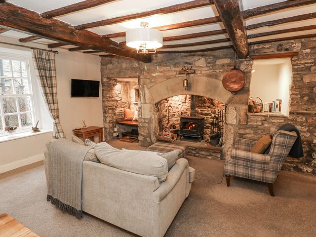 A living room with a fireplace and furniture at Chamber End Fold, Grassington