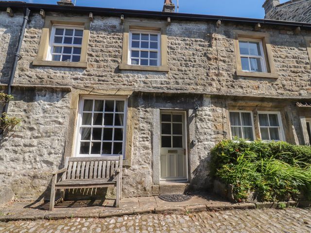 A stone cottage exterior with windows and a front door at Chamber End Fold Grassington