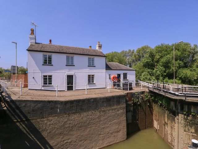 A house by a dock with a life buoy and bridge at The Lock House in Gloucester