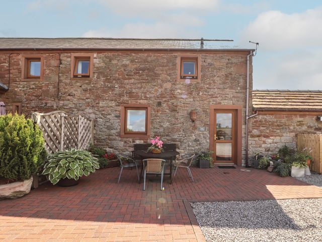 An outdoor area with a table and chairs at Piggery Cottage in Wigton